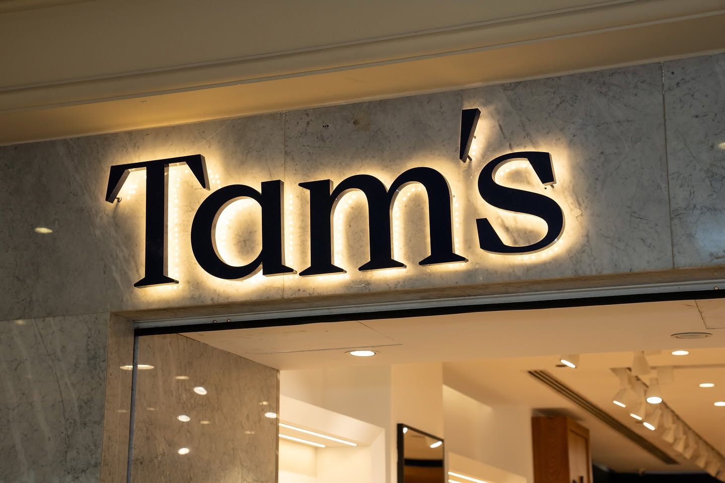 Tam's store front with illuminated logo